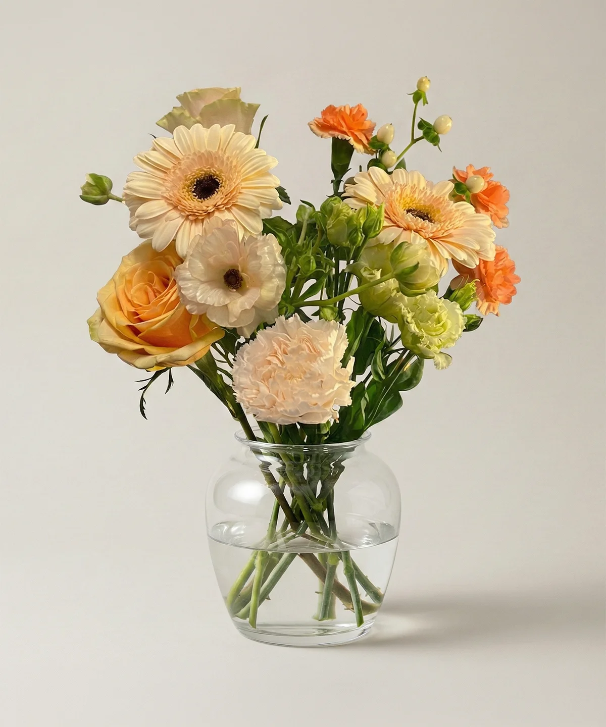 Champagne färg blombukett av färska snittblommor i glasvas från Nockebyhovs Blommor i Bromma, Stockholm.