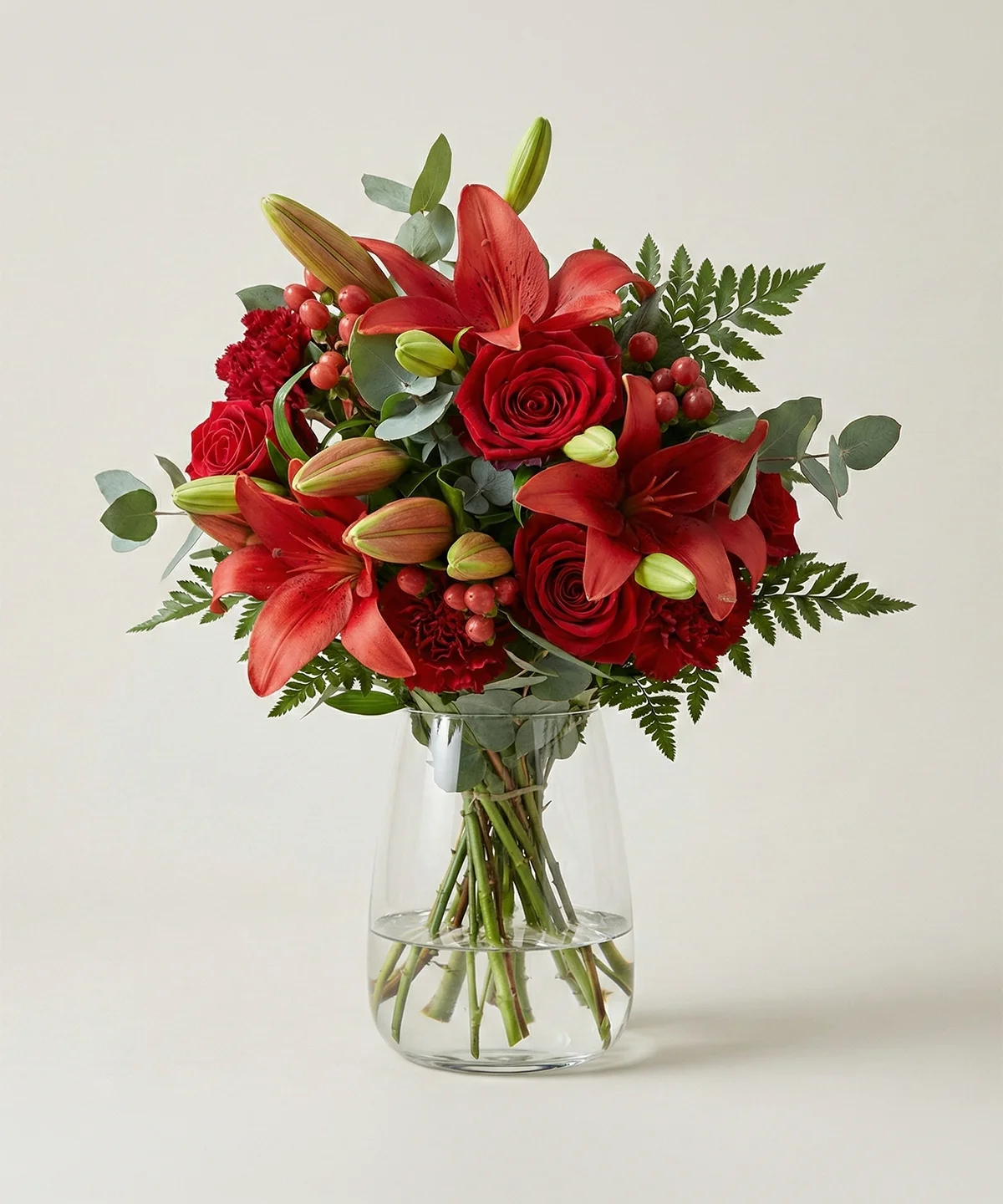 Blombukett av färska röda snittblommor i glasvas från Nockebyhovs Blommor i Bromma, Stockholm.